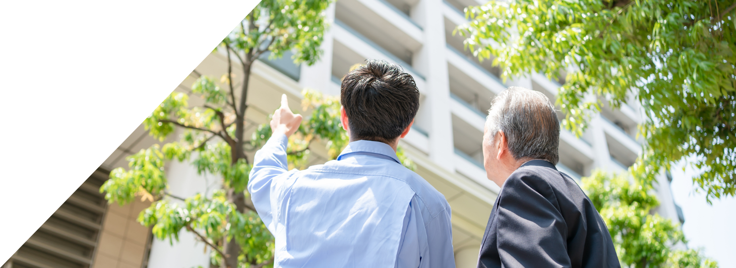 マンションを見ている男性2人の写真