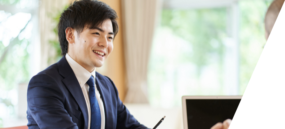 スーツを着用した人が椅子に座って話している写真