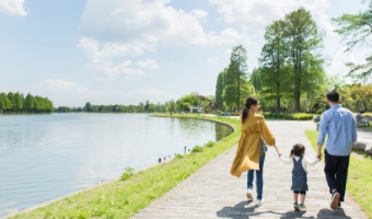 川沿いを女性・男性・子どもが歩いている